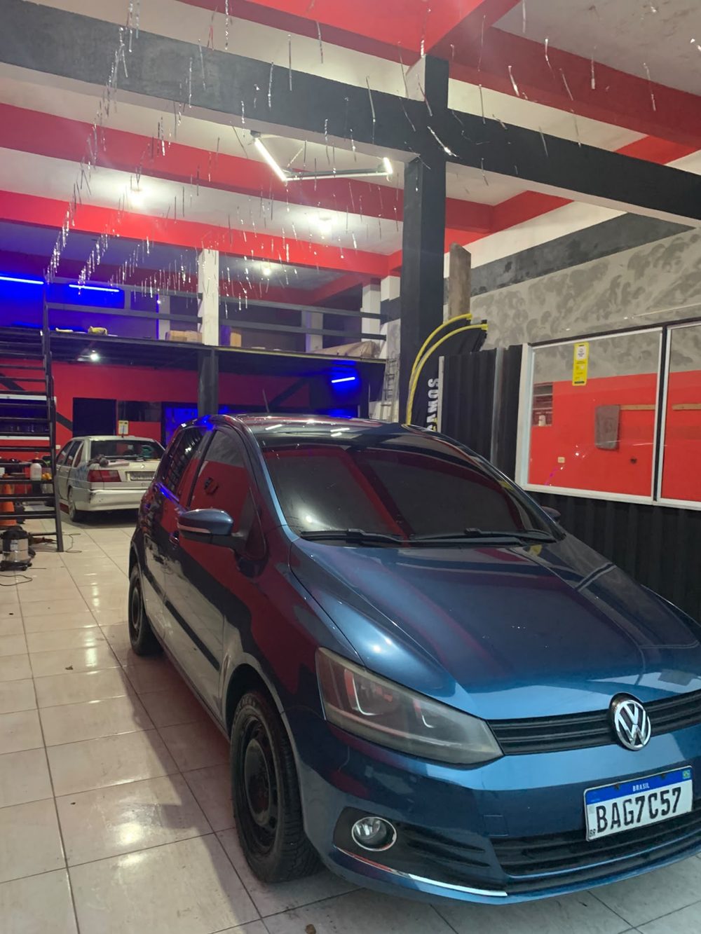 Carro azul com película escura dentro da loja Vinifilm Store