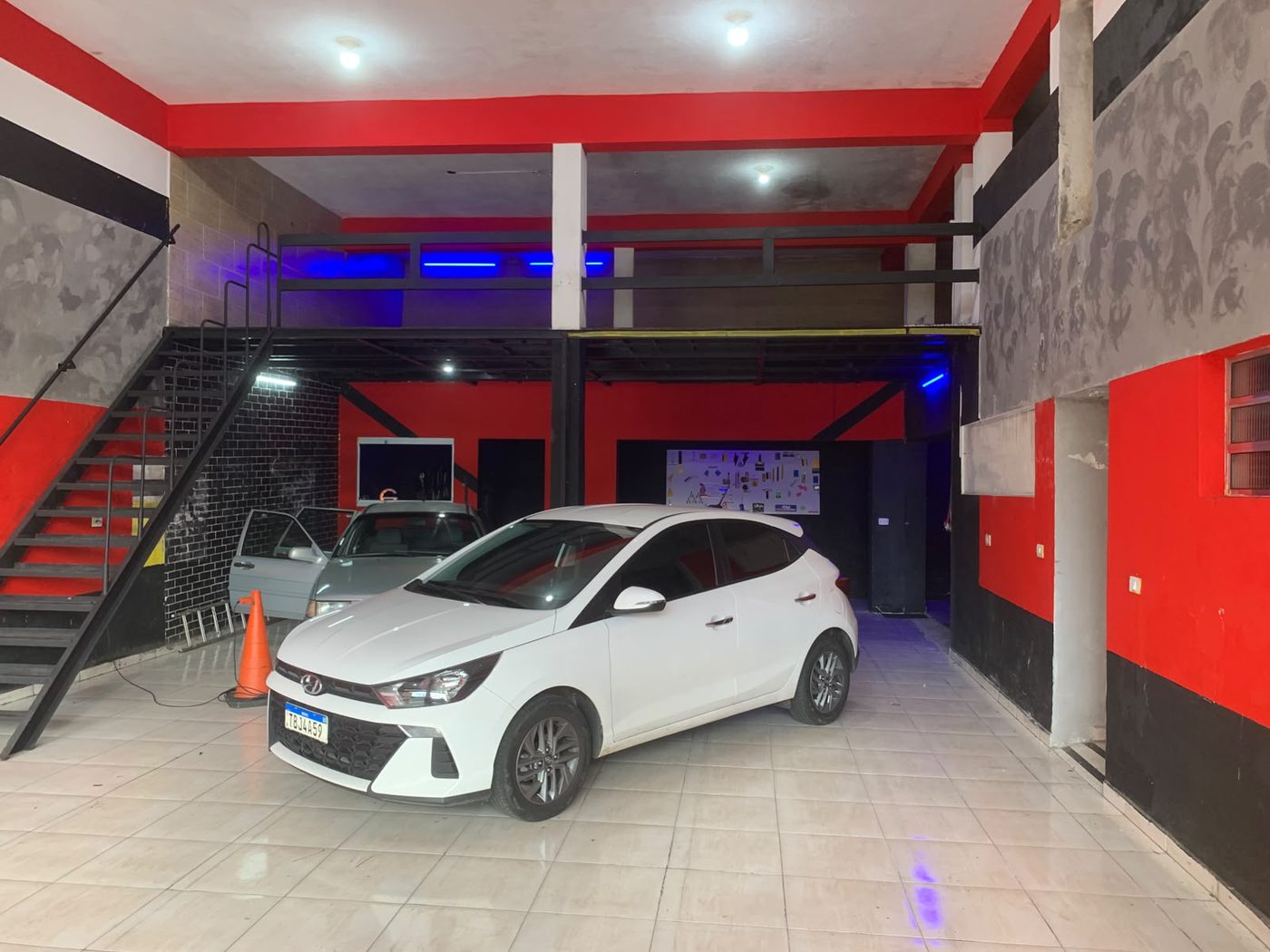 Salão interno da nova loja Vinifilm Store, com mezanino e vários carros